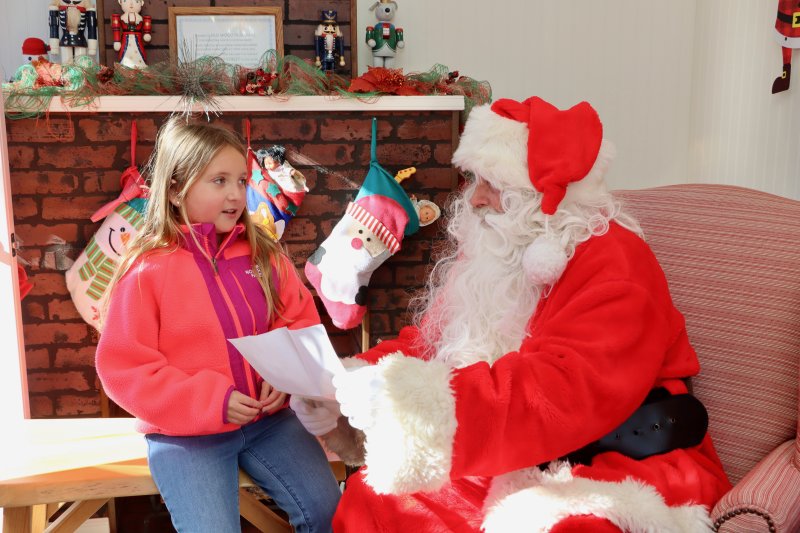 Addie Kaufman, 8, is among the first to give her Christmas list to Santa Claus in his home at Second and Bank streets.