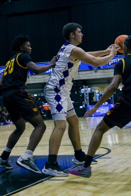 Royals senior Andrew Collins kicks the ball out as the defense collapses on him.