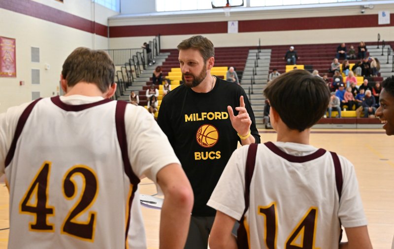 Cape grad and Milford coach Bob Croce reviews a play during a Milford timeout.