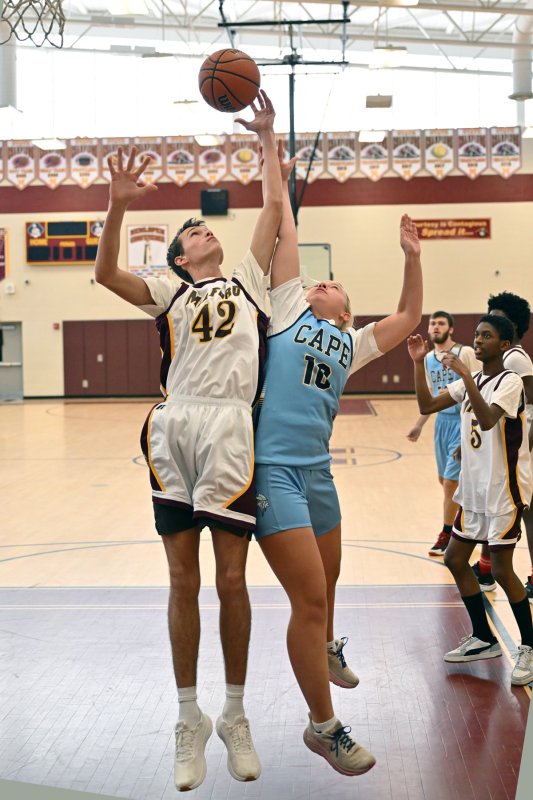 Cape unified partner Elizabeth Sprague, right, battles for a rebound with Milford partner James Sollie.