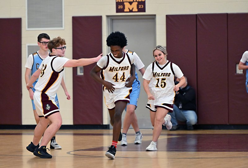 Milford’s Kaji Stevens has a big smile after scoring a basket.