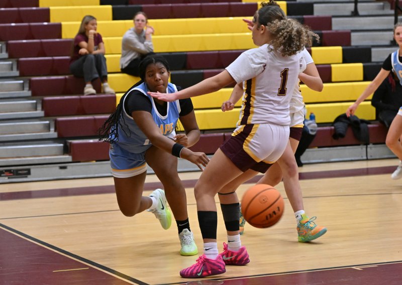 Cape sophomore Jordynn Bowe passes baseline around Milford’s Tristen Showell.