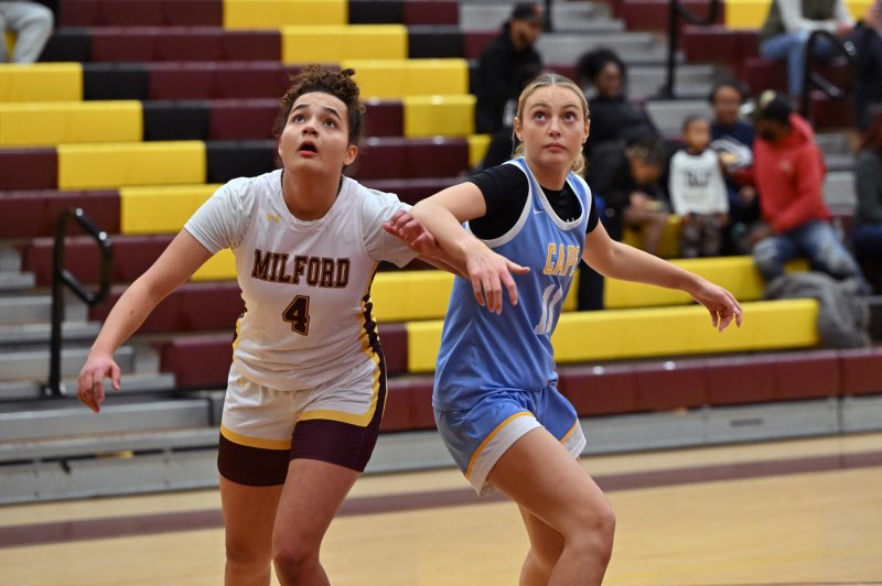 Cape senior Maya Yngve, right, battles for position with Milford’s Isabella Watson.
