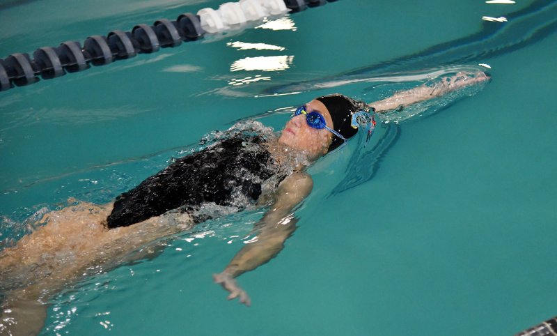 Freshman Sara Caldwell swims the 100 backstroke.