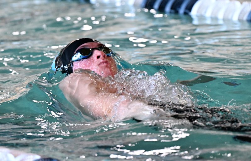 Cape junior Weston Bohl swims the backstroke leg of the winning medley relay team.