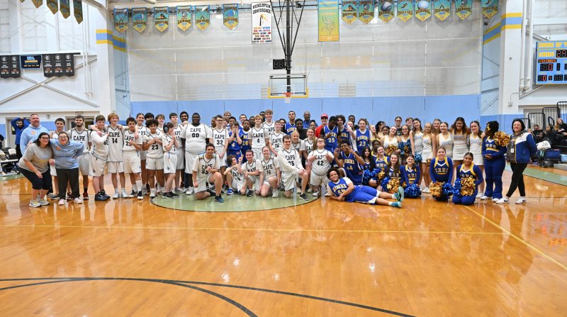 Both teams get together for a photo after the game.
