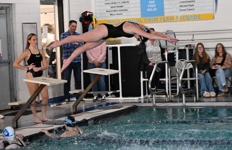 Junior Hayden Hazzard leaves the blocks as Julia Moore touches the wall in the medley relay.