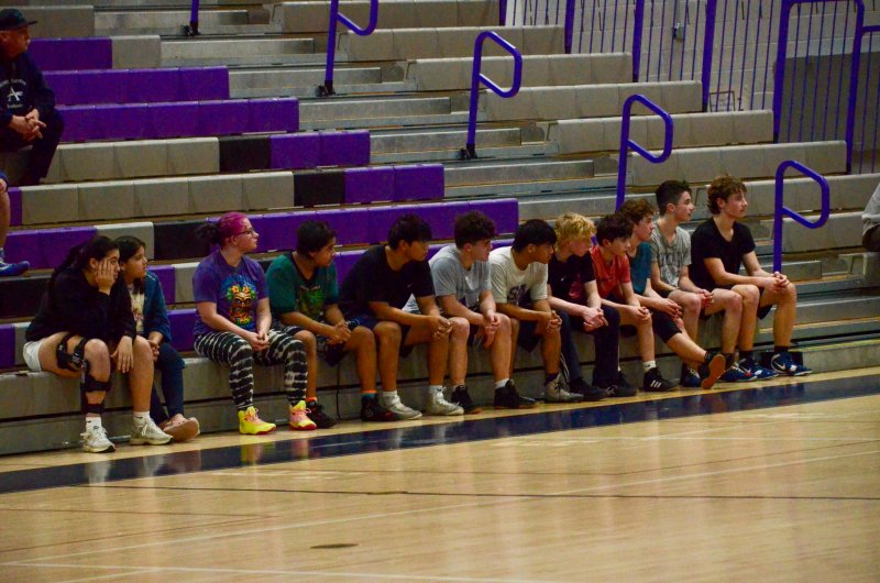 The wrestling team shows their support for the girls in the closing moments of the contest.
