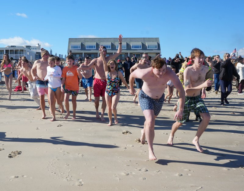A group sprints toward the ocean.