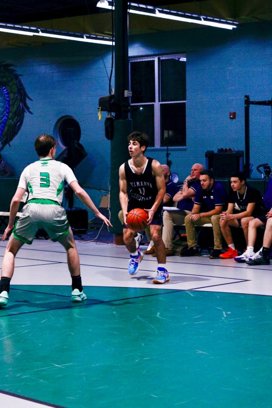 Royals junior Isaiah McCluskey handles the ball in front of the bench.