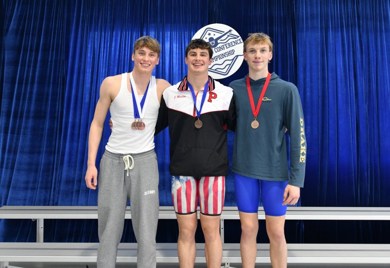 On the podium in the 100 backstroke are (l-r) third-place finisher Weston Bohl of Cape, winner Jacob Madden of Polytech and runner-up Michael Whitaker of Sussex Academy.