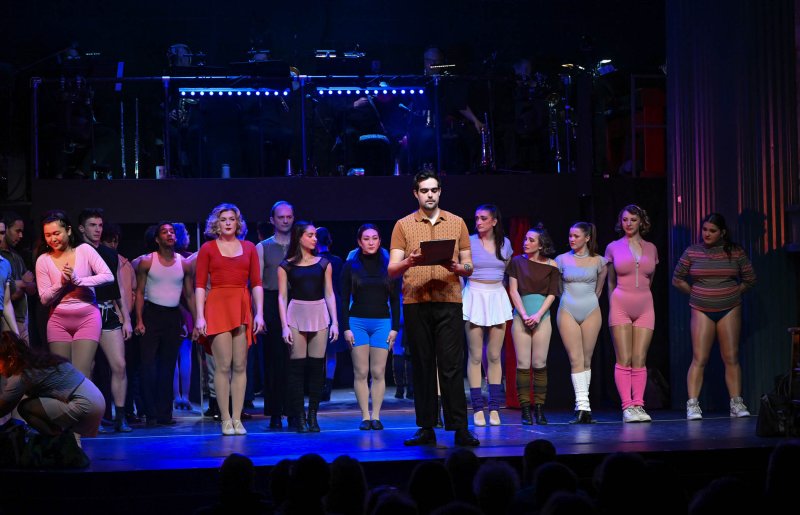 Zach, aka Jordan Kilgore, the director leading the audition, calls the dancers to formation.