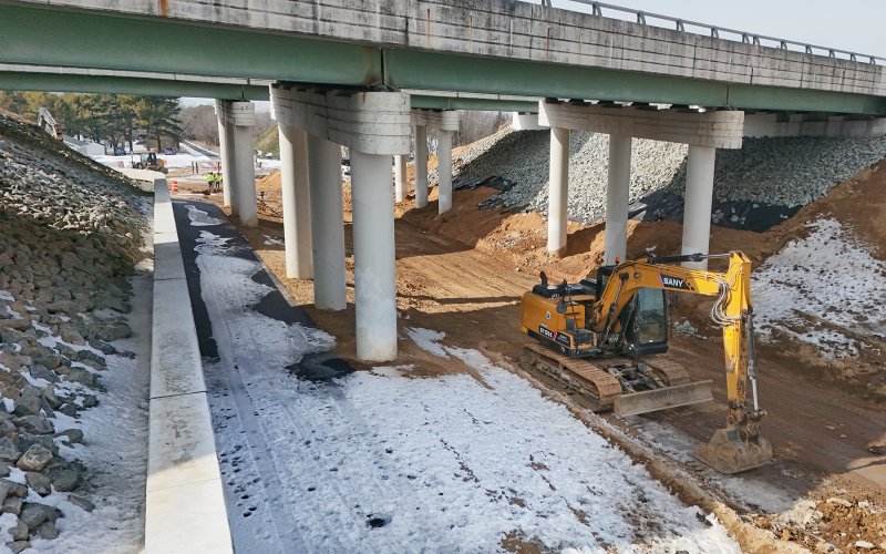 The snow-covered trail is now inside the bridge supports at the Nassau Bridge.