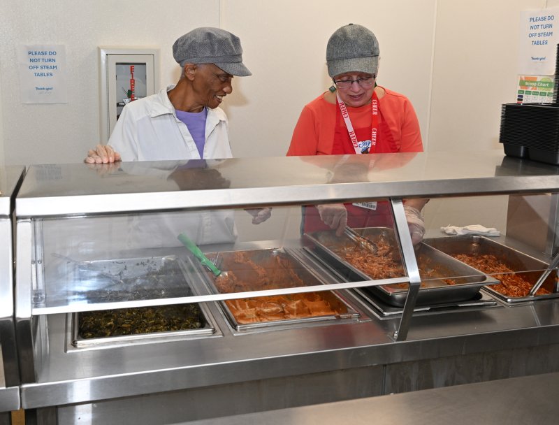 Ernestine Sheinall, left, and Cathy Tydings scoop out the nutritious food for the Meals on Wheels dinners.