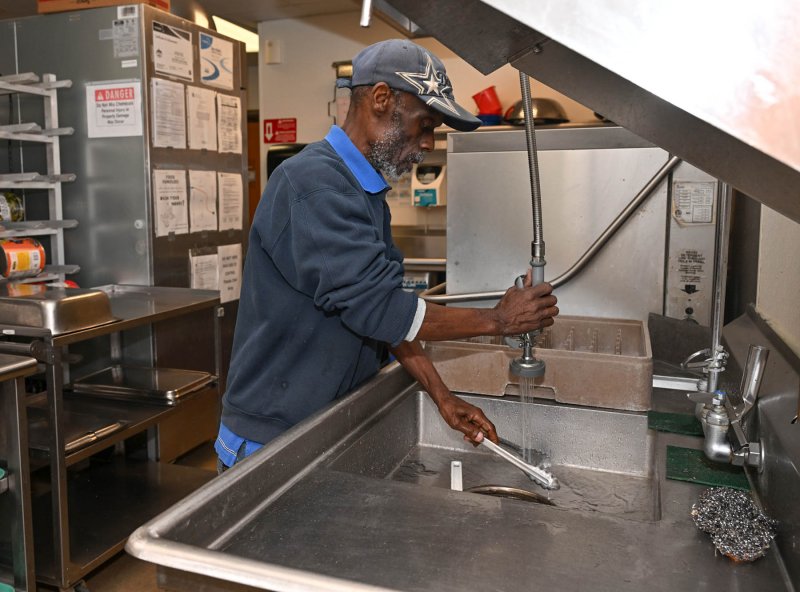 David Cannon cleans the utensils after the food is prepared.