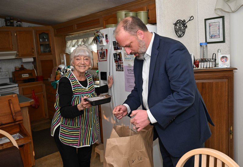 Nancy Pierce, left, looks forward to the visits from Meals on Wheels. Delaware State Housing Authority Director Matthew Heckles delivers her Meals on Wheels dinners and lunches for the March for Meals event. DAN COOK PHOTOS