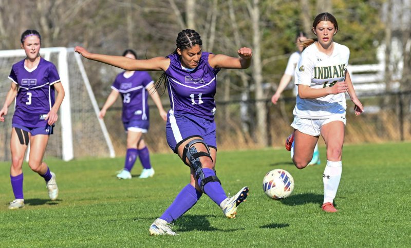 Royals senior Eva Elliott blasts the ball upfield against Indian River freshman Caroline Williamson. DAN COOK PHOTOS