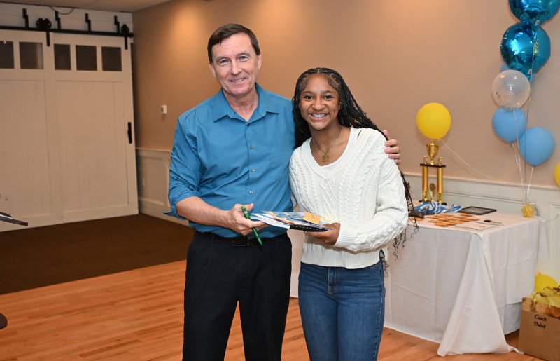 Freshman Natalie Horsey receives a varsity book from coach Ron Dukes.