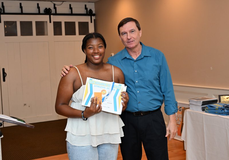 Sophomore Jordynn Bowe Natalie Horsey receives a varsity book from coach Ron Dukes.