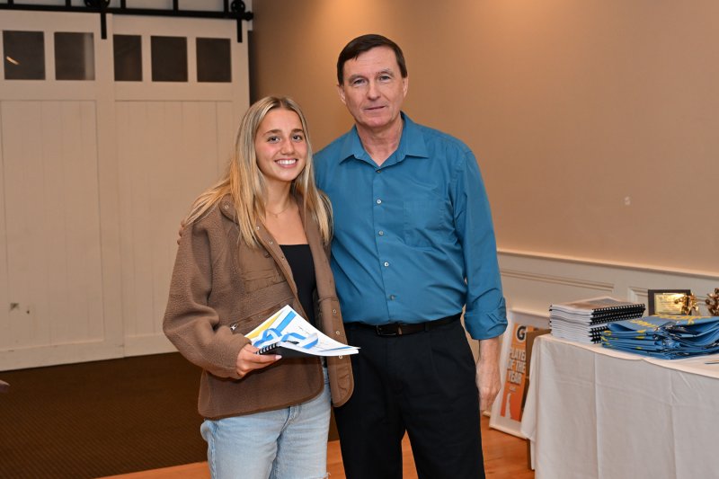 Sophomore Mikaela Gordon receives a varsity book from coach Ron Dukes.