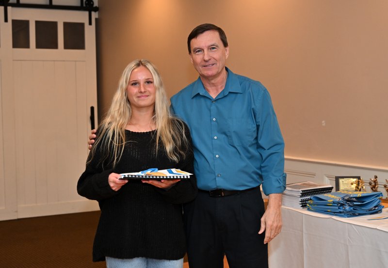 Junior Haley Gamuciello receives a varsity book from coach Ron Dukes.