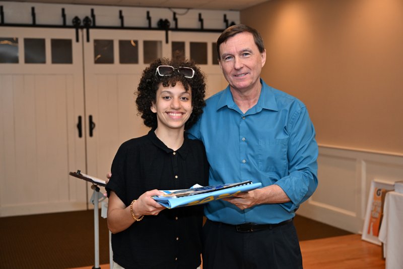 Senior Erinn Rodriguez receives the senior gift from coach Ron Dukes.