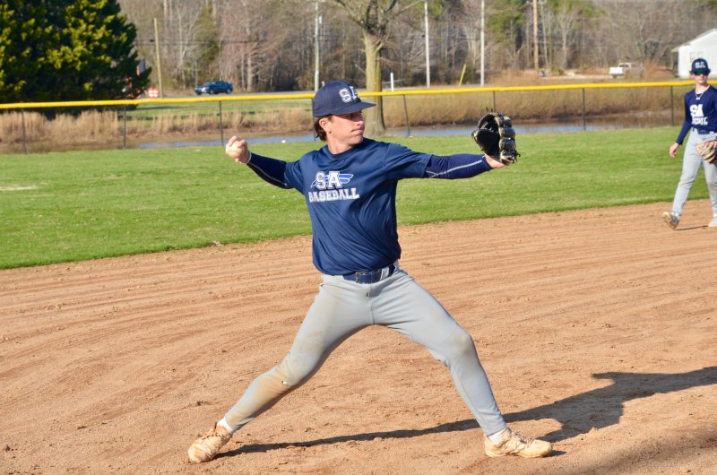 Sussex Academy senior Victor Goodhue throws over to first base.