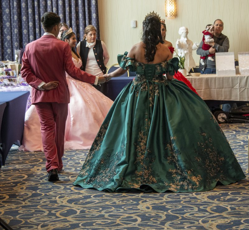 Maria Calles, in her green gown, is escorted off the runway.