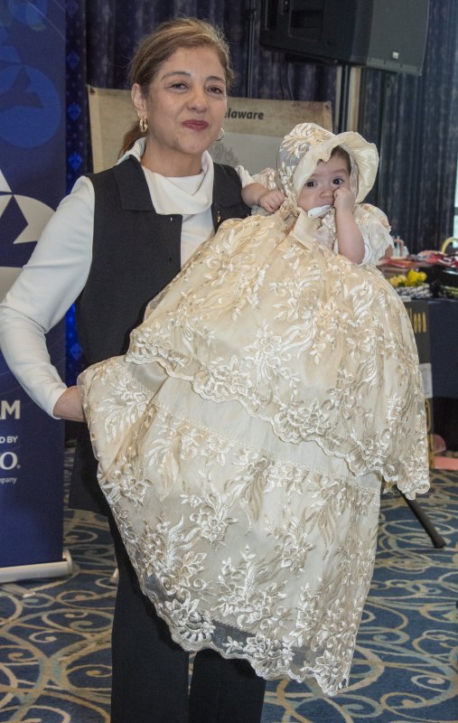 Guadalupe Castaneda holds Kamila Santana in a baptism gown from Luvida Co. Boutique.