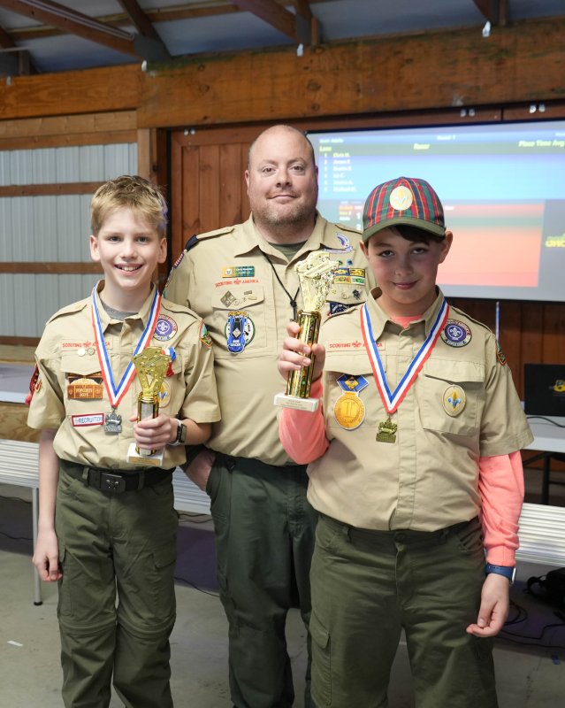 Cubmaster Chris Huebler stands with fifth-grade Arrow of Light Scouts Beau Berard, left, and George Dickinson.