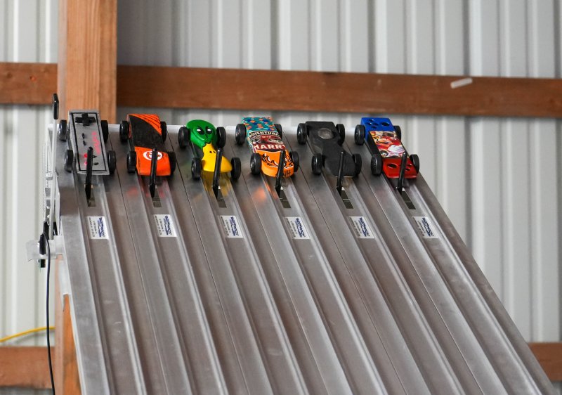 Six colorful cars wait at the starting line for the races to begin. The cars belong to (l-r) George Dickinson, James Huebler, Pierce Kenton, Saylor McKinney, James Cinque and Julien Berard.