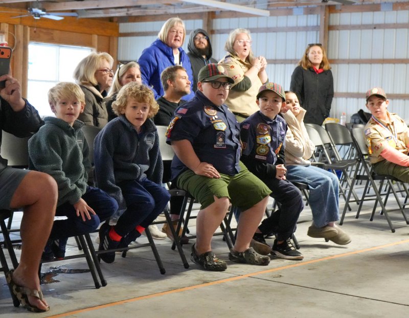 Cub Scouts and their family members watch a close race. The scouts shown are (l-r) Sawyer McKinney, Saylor McKinney, James Cinque, Jackson Snyder and George Dickinson.
