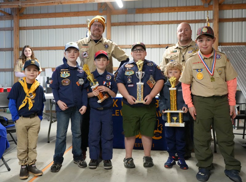 After the derby, the scouts who competed in the grand finals hold up their trophies. In back are (l-r) Arrow of Light Den Chief CJ Walsh, Assistant Cubmaster James Fisher and Cubmaster Chris Huebler. In front are Pierce Kenton, Lion Scout; James Huebler, Bear Scout; Julien Berard, Wolf Scout; James Cinque, Webelos Scout; Saylor McKinney, Tiger Scout; and George Dickinson, Arrow of Light Scout.