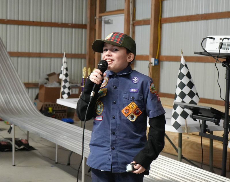 Jackson Snyder, a Webelos Scout, sings happy birthday to Assistant Cubmaster Liz Cinque after the derby.