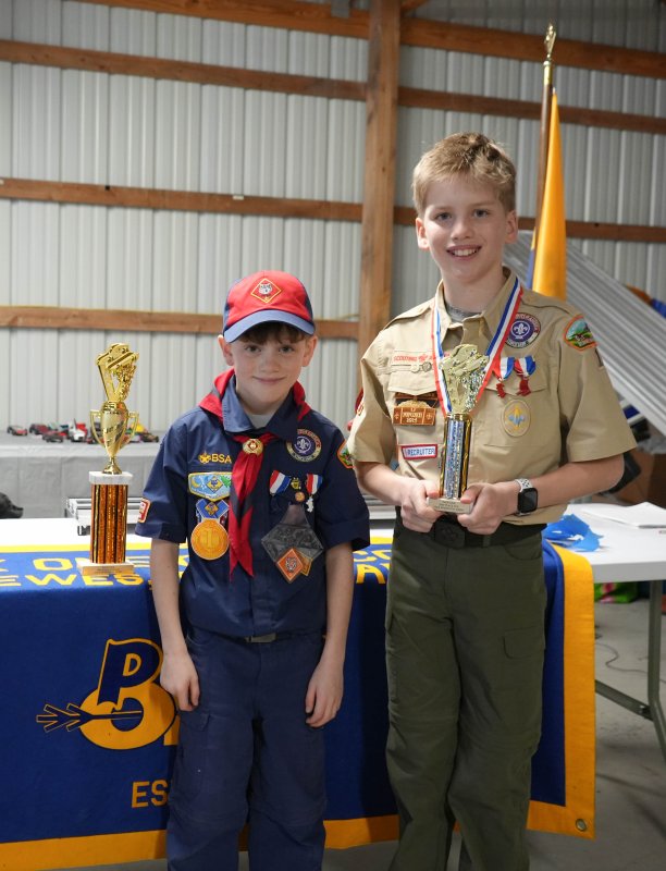 Julien Berard, a Wolf Scout, left, and his brother, Beau, an Arrow of Light Scout, stand with their trophies after the final race.