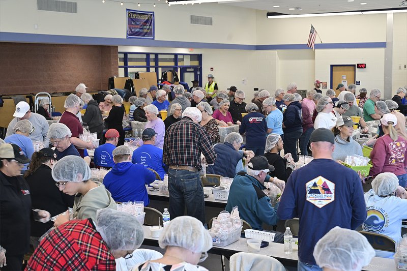 Volunteers gather during a previous Rise Against Hunger event to assemble meals with rice, soy, dehydrated vegetables, and a micronutrient packet containing 20 essential vitamins and minerals for shipping to needy children. FILE PHOTO