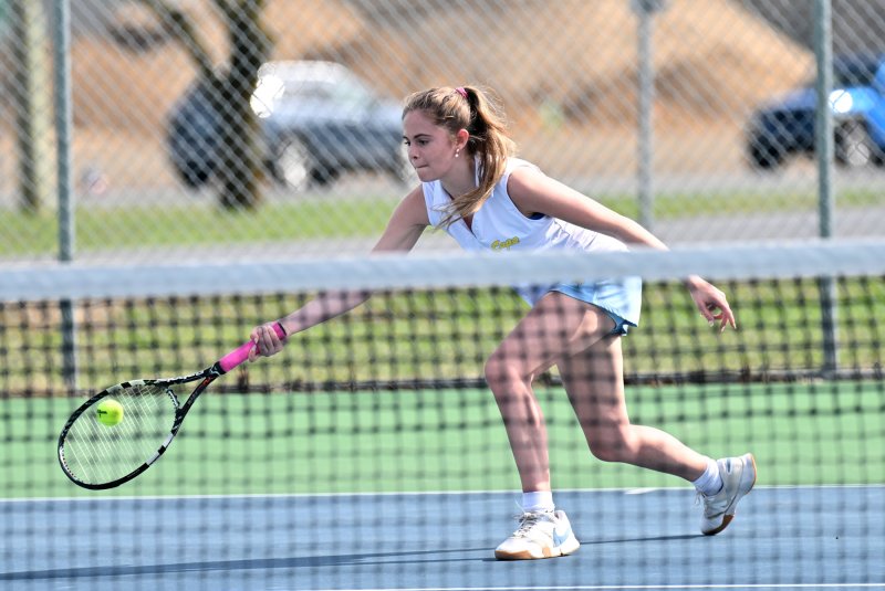 First singles Julia DiSabatino hits a low volley and defeated Martine Laguerre 6-0, 6-0.
