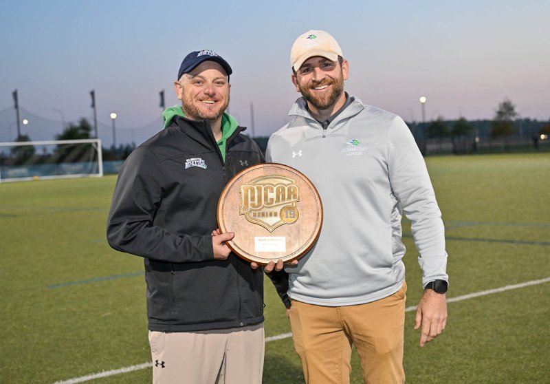 Franc Cook, left, program manager of athletics for the Terry Campus, presents the Region 19 Championship plaque to head coach Dan Yearick.