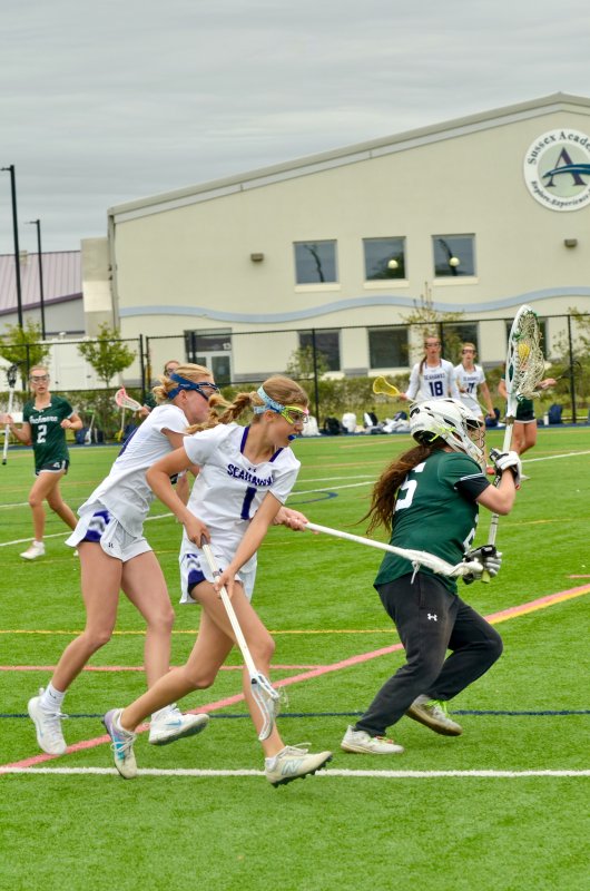 Seahawks junior June Hale, left, and Brooklyn Montgomery team up to redirect Mia Luce on a clear.