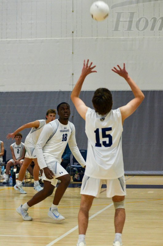 Seahawks senior Vito Barone sets the ball for Mack Lawson, left, and Jovan Jean-Louis.