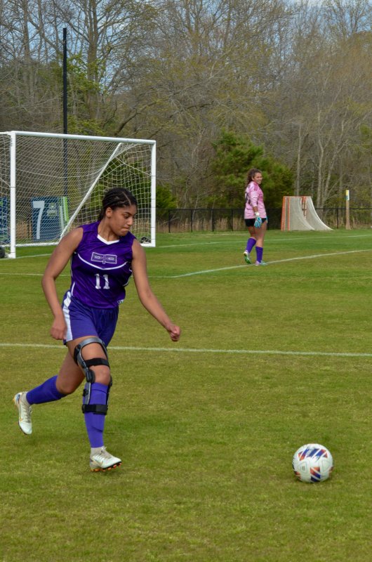 Delmarva Christian senior Eva Elliott begins to clear the ball.