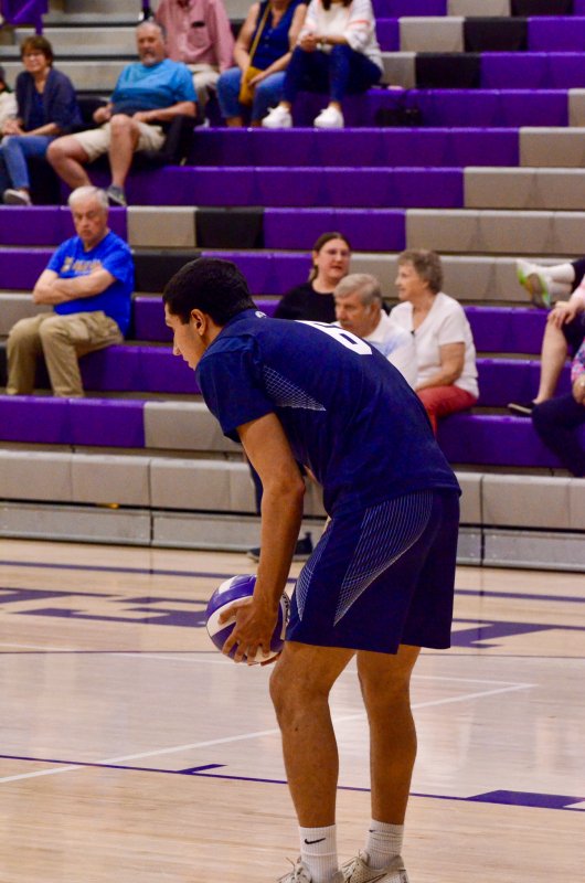 Sussex Academy Christian Wright prepares to serve with his family in the background.