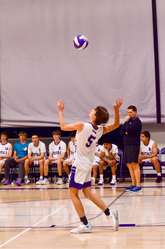 Royals senior James Baxter serves the ball.