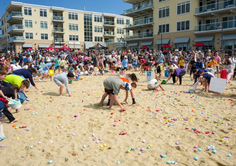 Colorful Easter eggs dot the sand on the bay beach for the 2026 Dewey Egg Scoop.