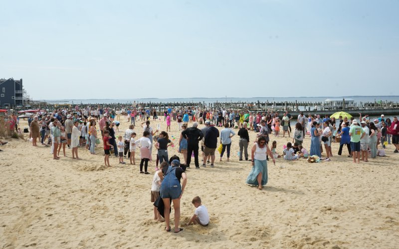 A crowd of people fills the bay beach near the Lighthouse in Dewey Beach for the Easter Egg Scoop.