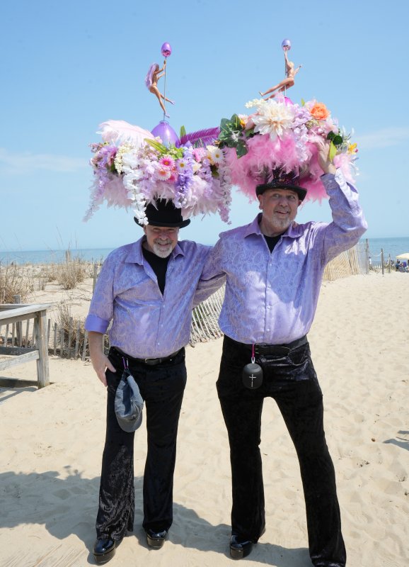 John Rafter, left, and Bob Bieber wear matching purple shirts and elaborate bonnets complete with speakers to play music.